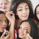 Women applying makeup in mirror