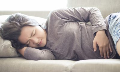 Woman Suffering from Stomachache on Sofa